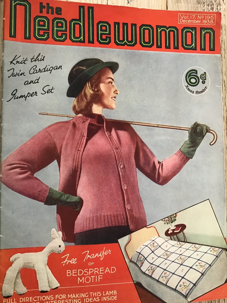 Magazine cover - woman in pink twinset and black hat, with cane across shoulders. Price marked as 6d. Text says "Knit this Twin Cardigan and Jumper Set". Stuffed toy lamb and bedspread at front. Text "Free Transfer for BEDSPREAD MOTIF".